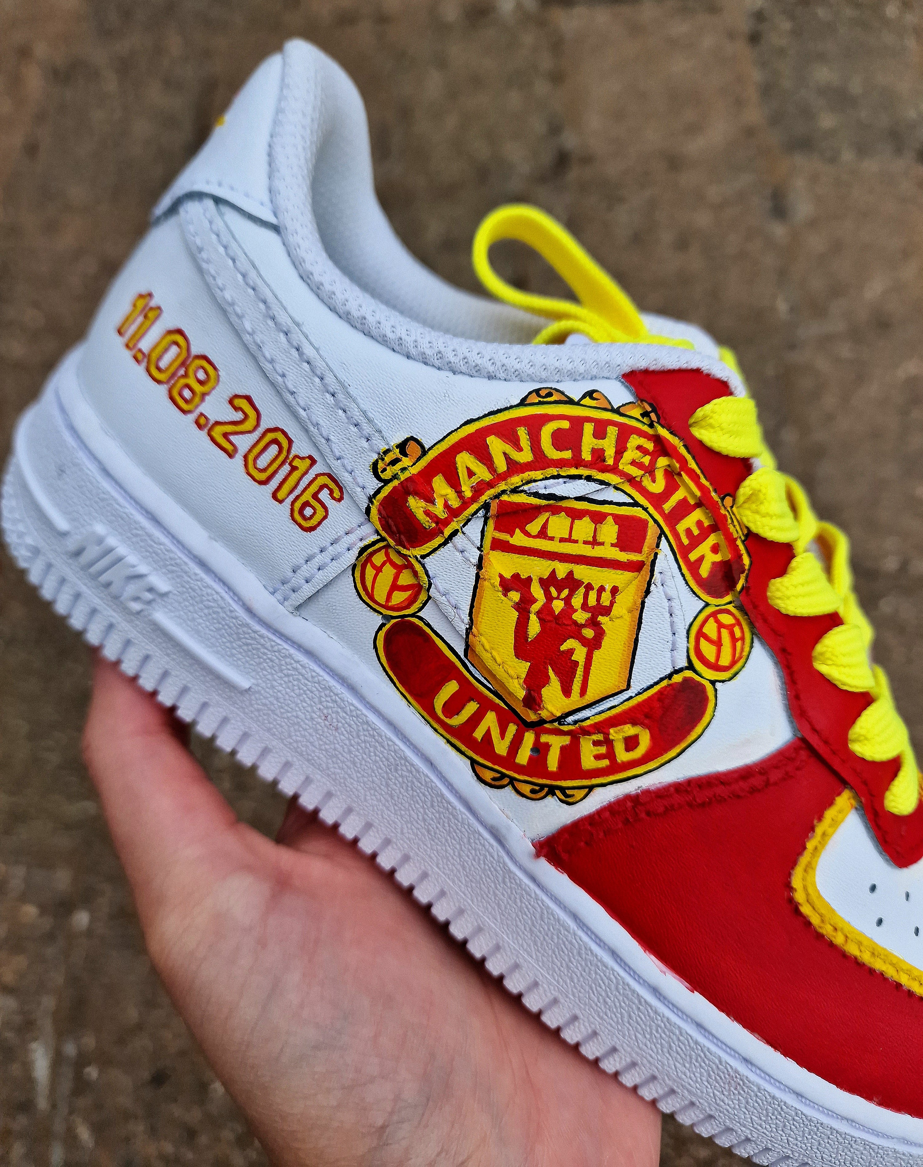 Hand-painted custom sneakers featuring the Manchester United crest, Marcus Rashford kit illustration, and personalized details on a red, yellow, and white theme; perfect for football fans.

