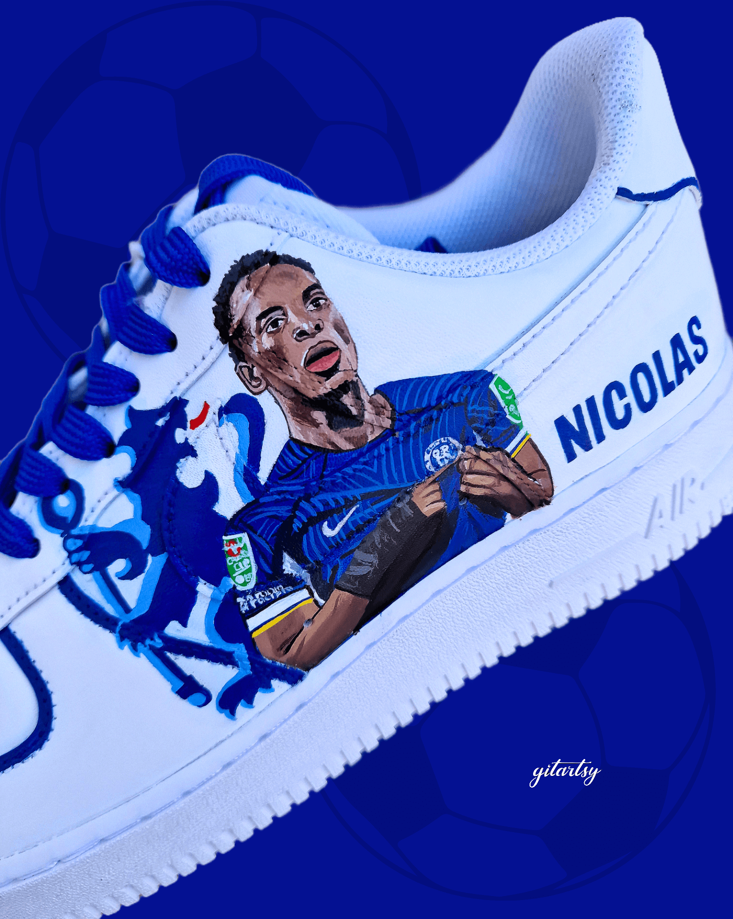 Custom hand-painted white sneakers featuring Chelsea FC’s Nicolas Jackson in vivid blue match kit, complete with the club badge and Senegal flag-inspired Nike swoosh. Designed by Gitartsy, the artwork includes realistic player portraits, fine detailing, and premium waterproof paint, making these shoes a perfect blend of fashion and football art.

