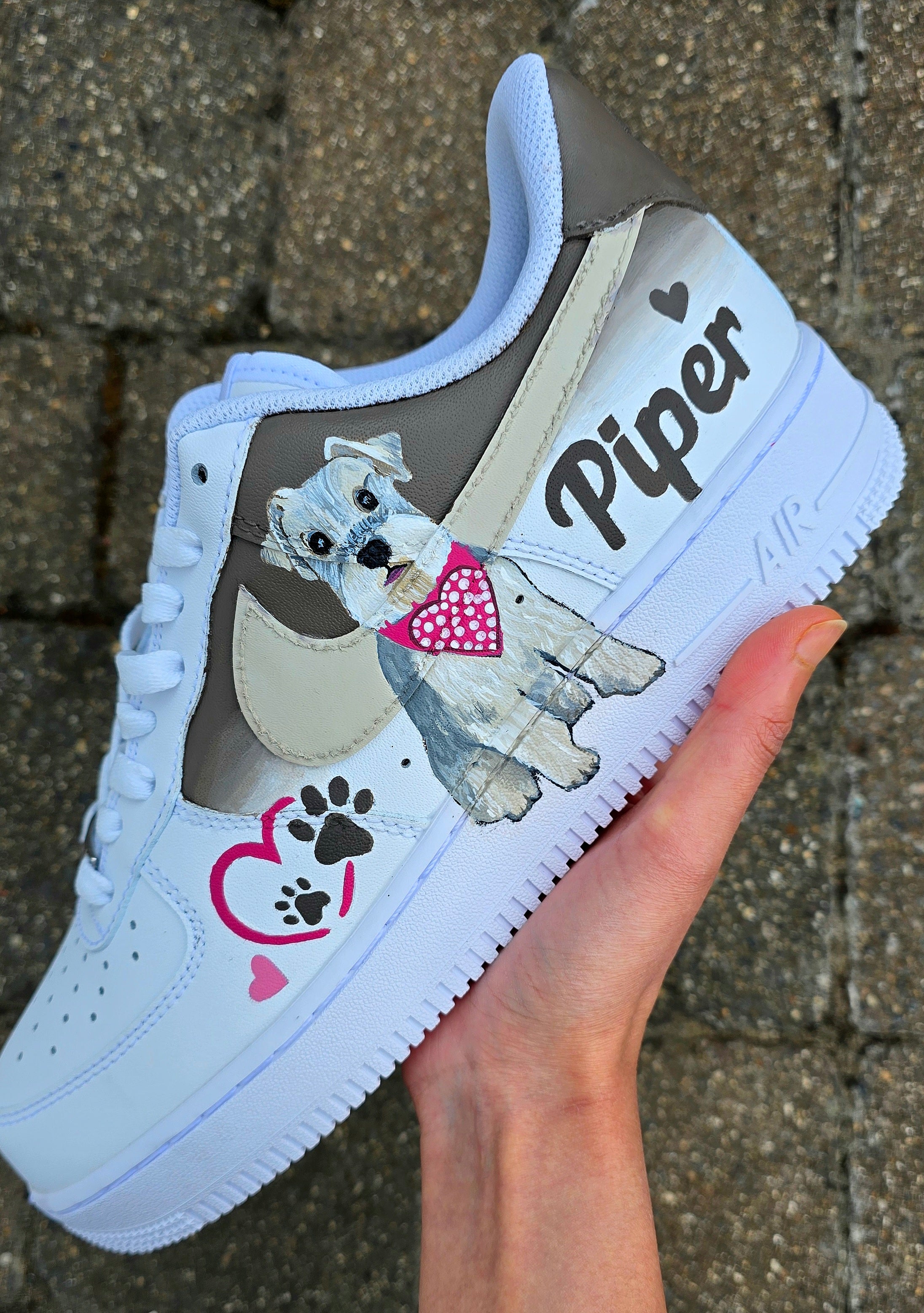 Hand-painted Nike Air Force 1 custom sneakers featuring a realistic pet portrait of “Piper” the dog 🐾, pink or taupe background, heart ❤️ and paw print accents, and personalised name detail, created by Gitartsy.

