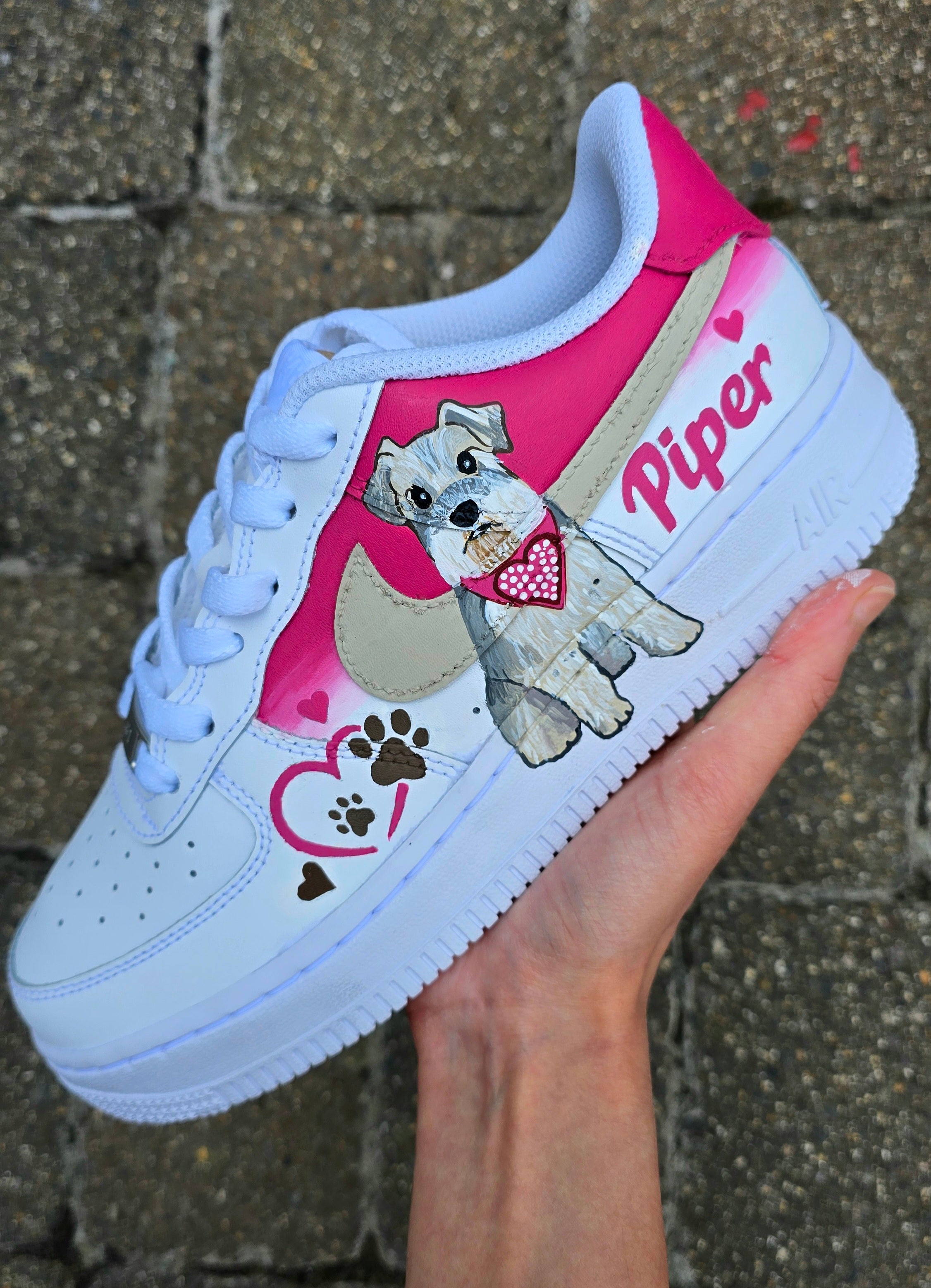 Hand-painted Nike Air Force 1 custom sneakers featuring a realistic pet portrait of “Piper” the dog 🐾, pink or taupe background, heart ❤️ and paw print accents, and personalised name detail, created by Gitartsy.


