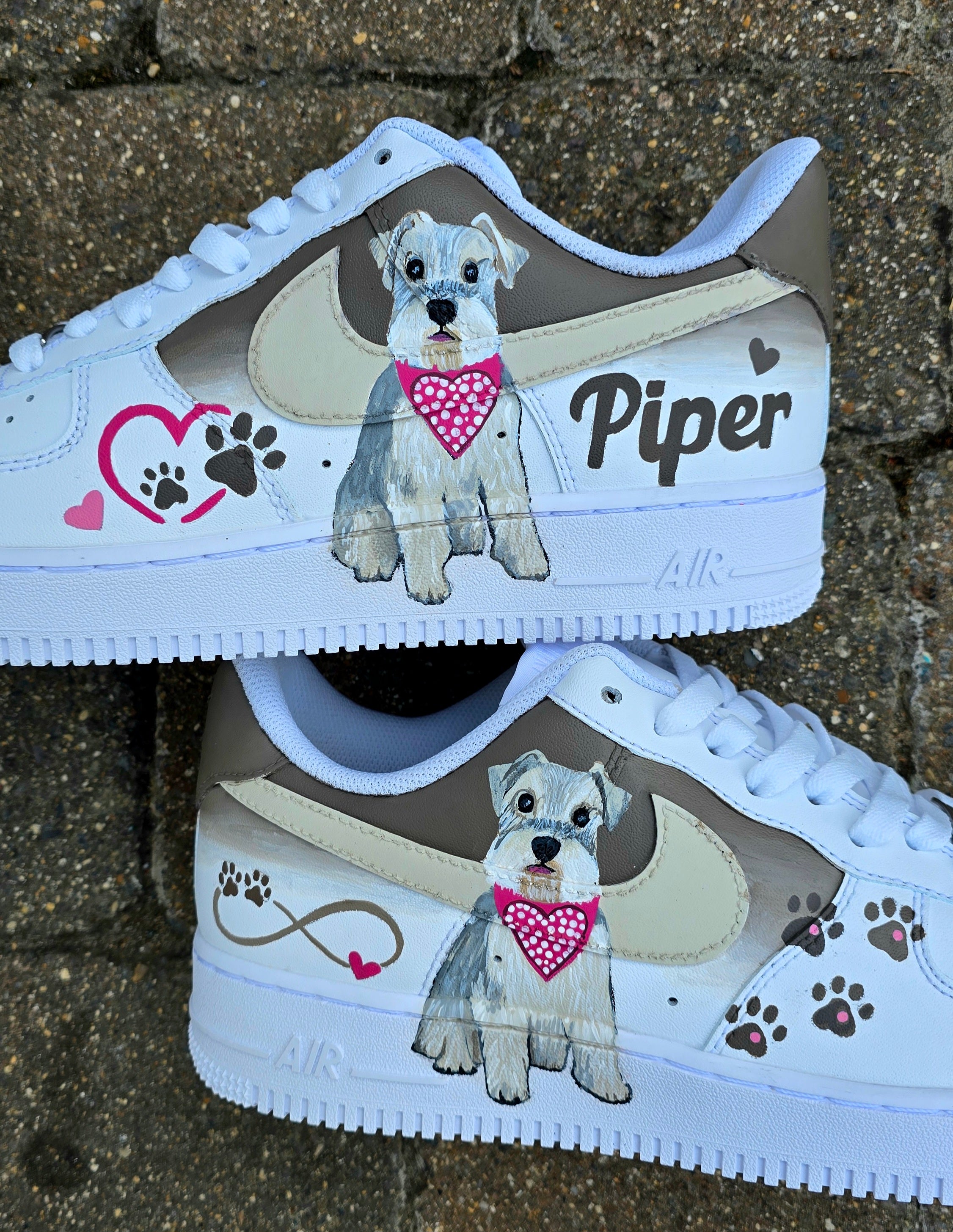 Hand-painted Nike Air Force 1 custom sneakers featuring a realistic pet portrait of “Piper” the dog 🐾, pink or taupe background, heart ❤️ and paw print accents, and personalised name detail, created by Gitartsy.

