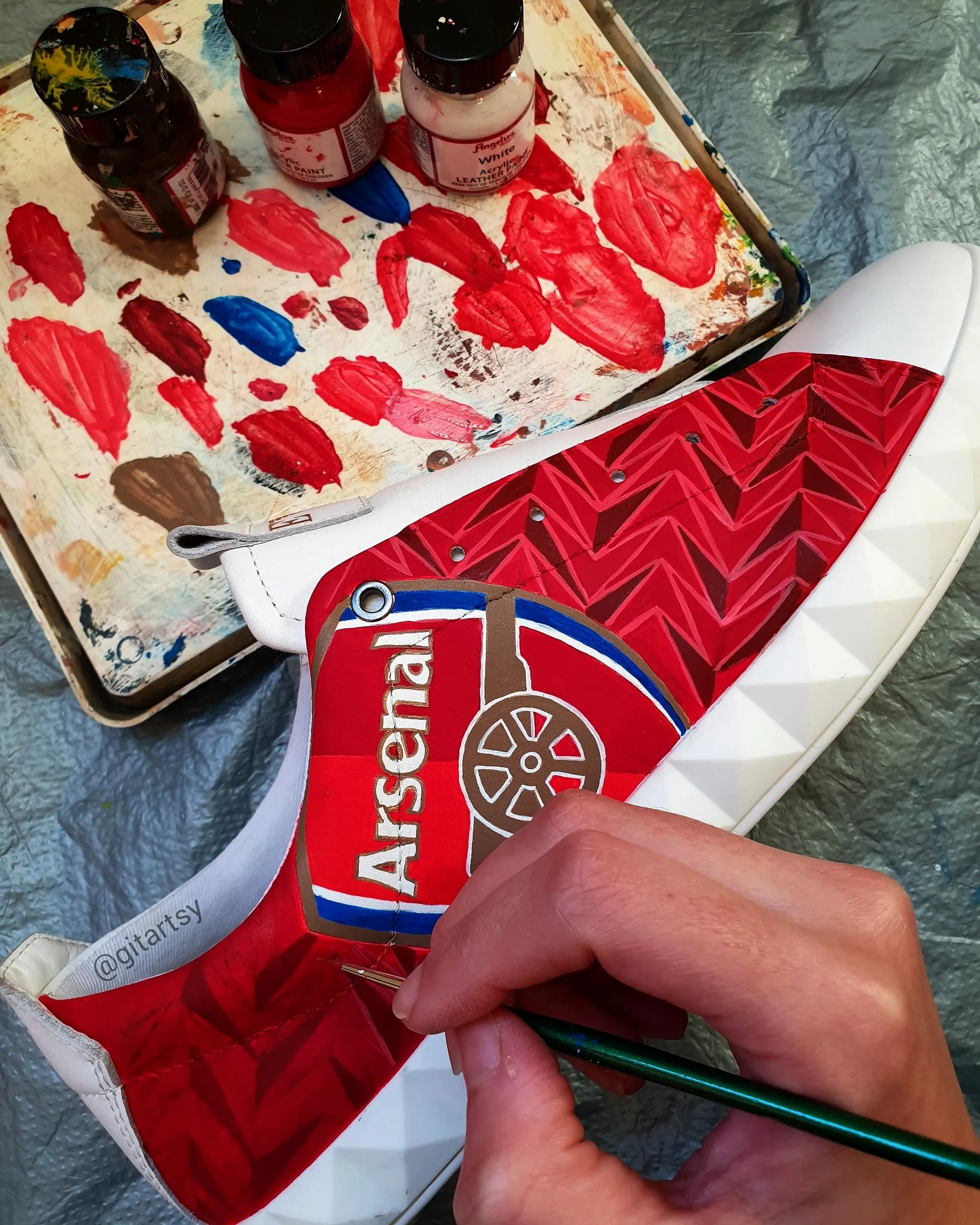 Realistic portraits of footballer Pierre-Emerick Aubameyang and Arsenal FC logo hand painted on white Armani sneakers shoes