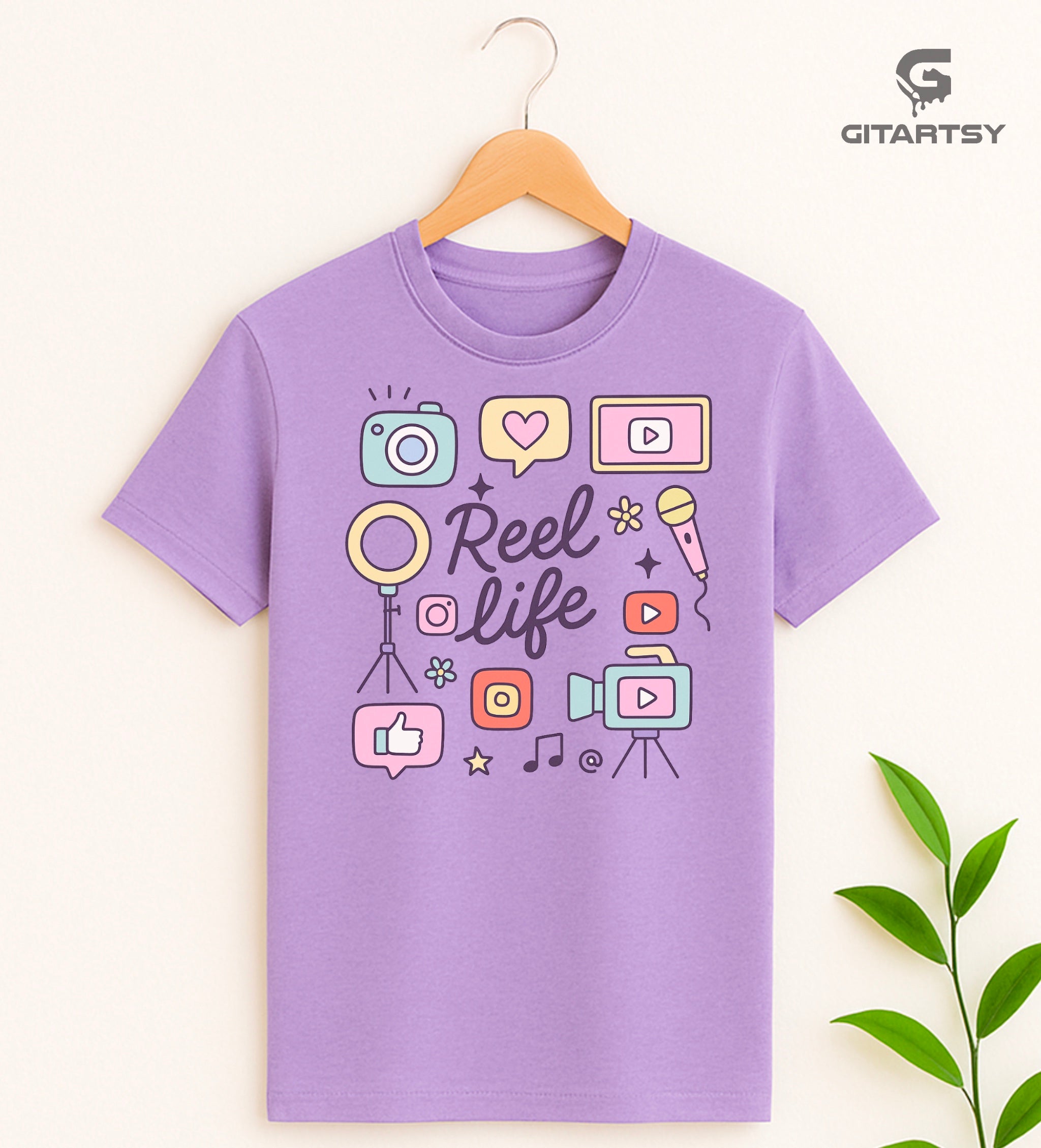 Pastel “Reel Life” T-shirt with social media icons, camera, microphone, and content creator doodles – ideal for influencers, vloggers, and content creators