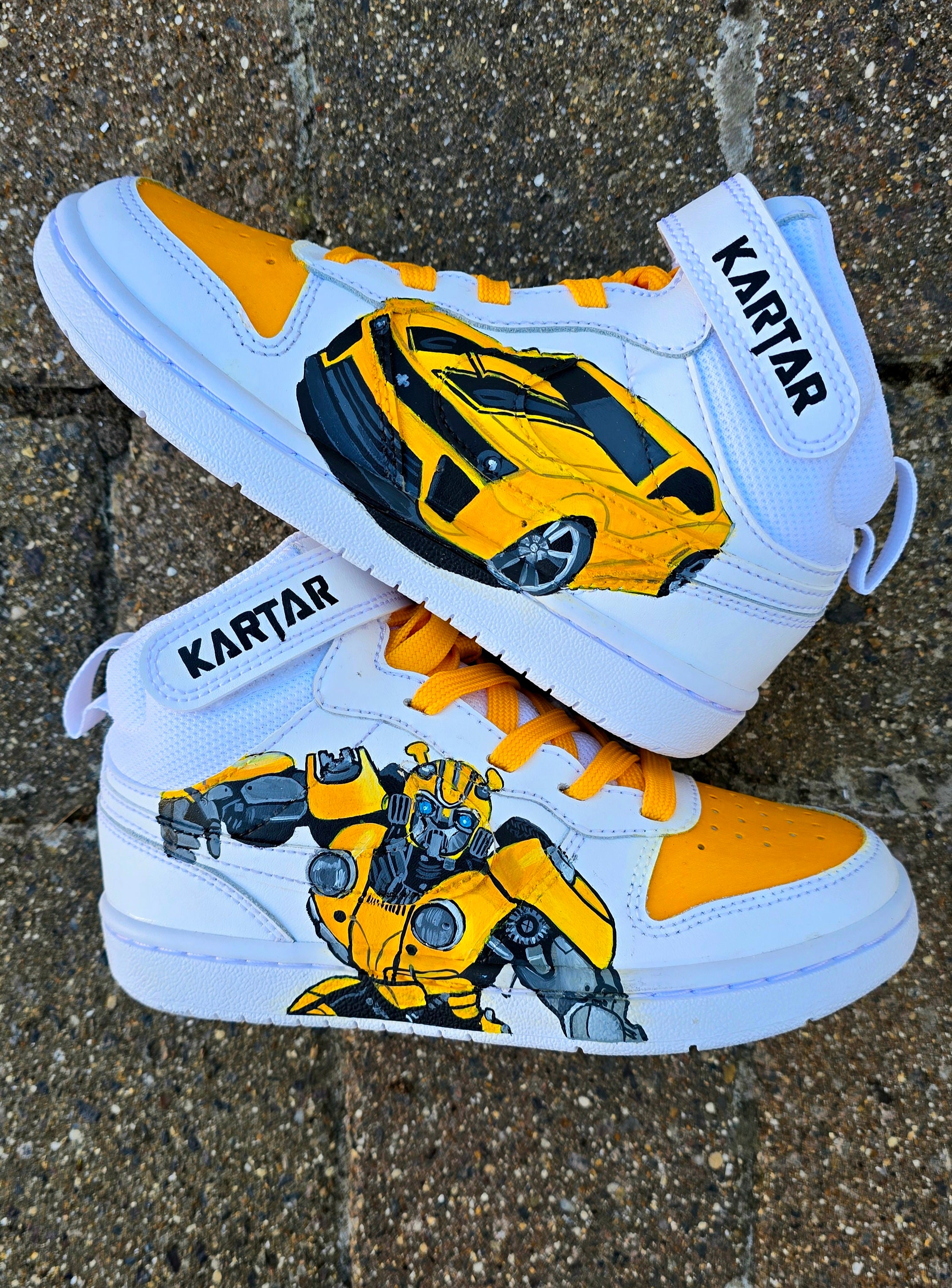 Custom hand-painted Nike AF1 sneakers for kids featuring vibrant Transformers Bumblebee artwork in both robot 🤖 and car 🚗 form. Designed with bright yellow, black, and metallic grey detailing, sealed with a waterproof finish for long-lasting wear. Perfect for young Transformers fans and collectors.

