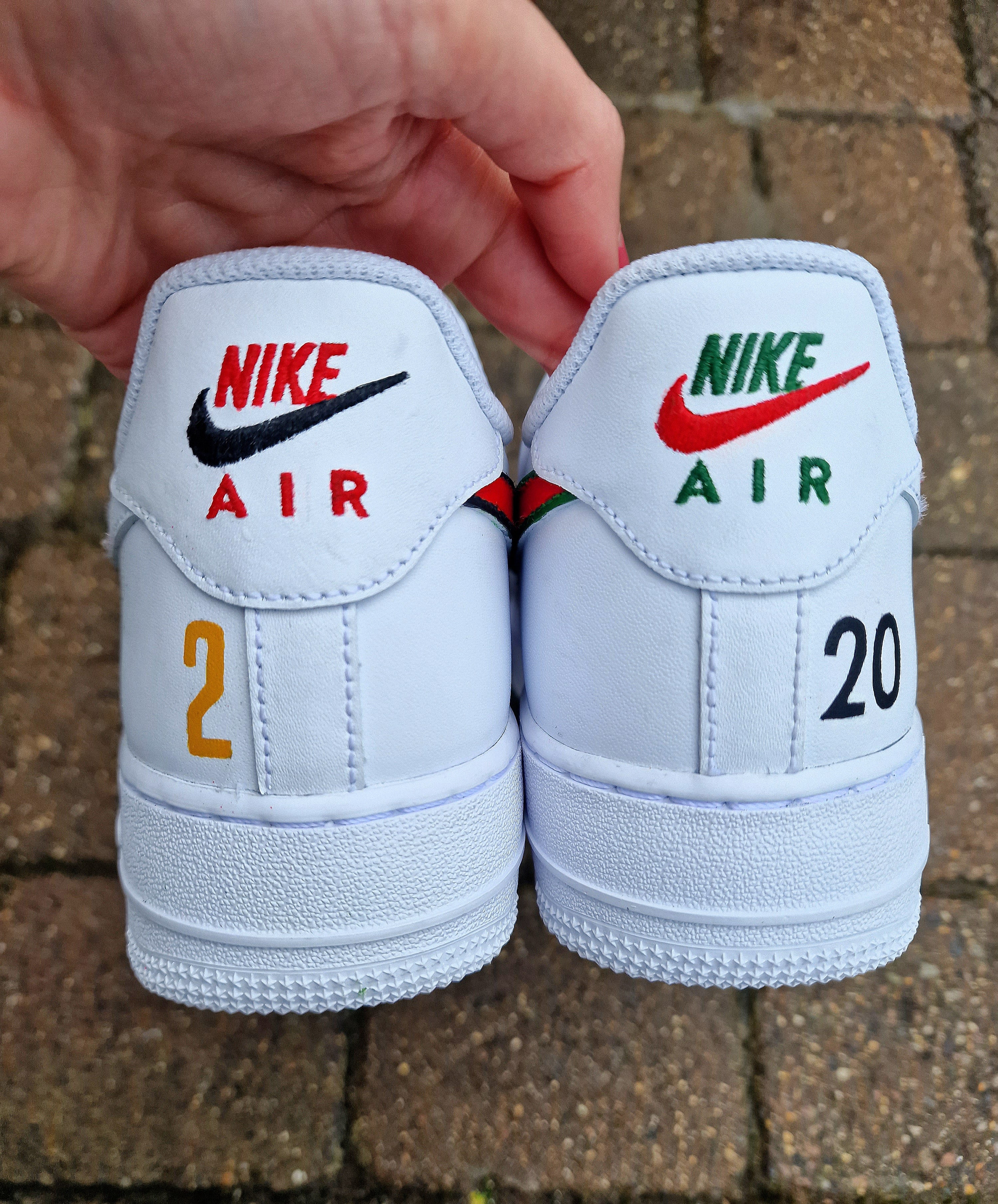 "Custom hand-painted Nike Air Force 1 sneakers featuring Manchester United and Portugal national football team crests, splattered in bold red, green, and black paint with unique details, crafted by Gitartsy."

