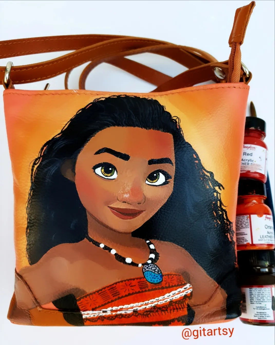 A portrait of Disney Moana hand painted on a yellow/brown leather bag