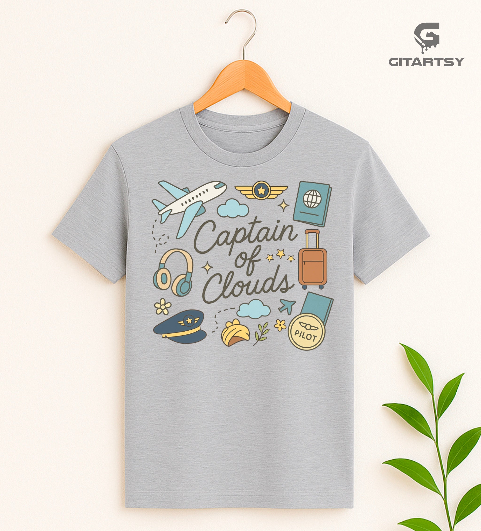Pastel pilot-themed t-shirt with plane, cloud, headset, and travel icons. "Captain of Clouds" design for aviation lovers and airline crew.